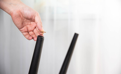 A man glues protective pads on the legs of a chair. Protection against floor scratches and noise
