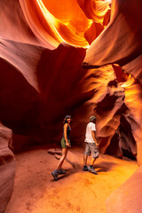 A young couple tourist in a crack in Lower Antelope, Arizona. United States - obrazy, fototapety, plakaty