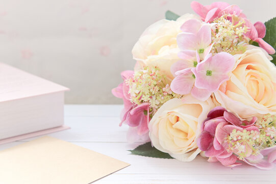 記念日のプレゼント｜花束と封筒と洋書