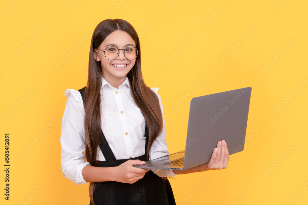 Wall mural happy child in school uniform and glasses study on laptop, back to school