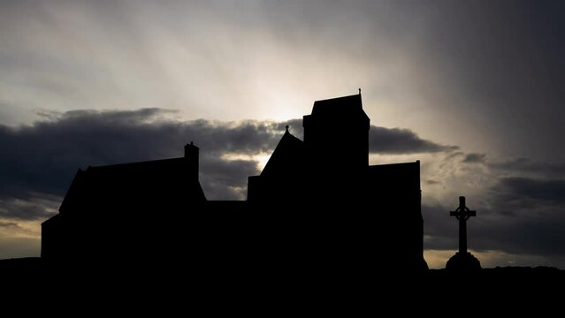Iona abbey in Scotland, Time Lapse at Sunrise with Fast Clouds and Dark Silhouette of Medieval Church