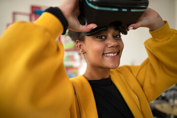 Happy student wearing virtual reality goggles at school in computer science class