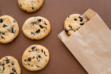 Top view of cookies and craft package on brown background.