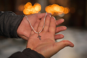 The priest holds a golden pectoral cross in his hands.
Golden cross close-up against the background...