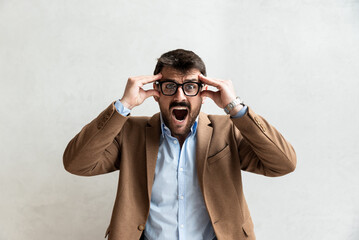 Young office worker mad by stress screaming. Frustrated business man yelling from anger and frustration after he got fired and lost his job. Unemployment concept