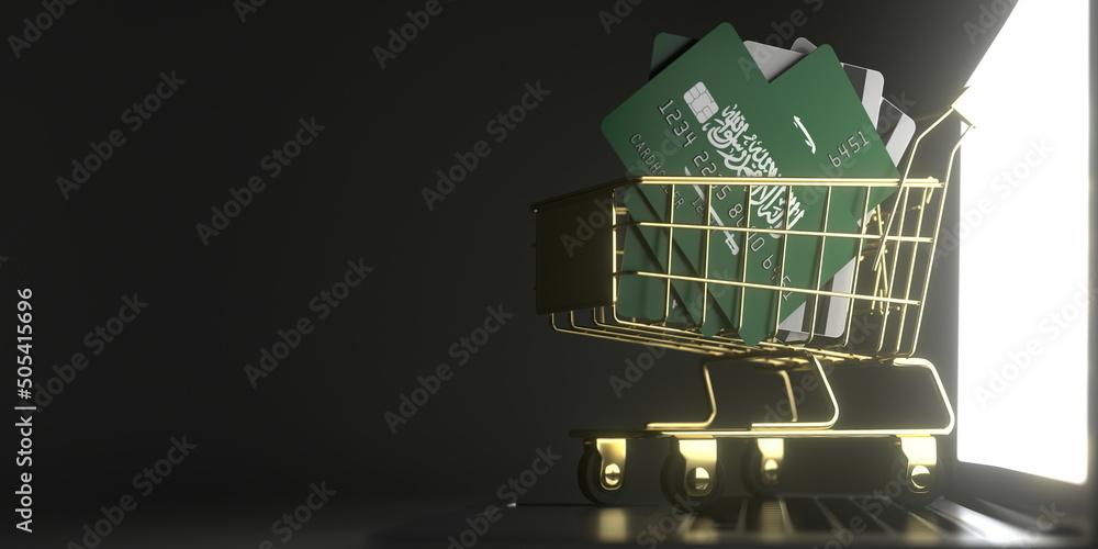 Poster bank card mockups with flags of saudi arabia in a small shopping cart on the computer. conceptual 3d