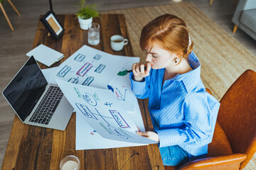 Fototapeta na wymiar Female businesswoman readind financial report analyzing statistics pointing at pie chart working at her desk. Businesswoman examining documents at desk