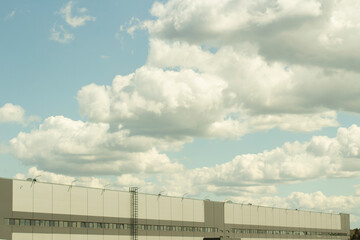 Warehouse and sky. Grey building. Clouds over the warehouse.