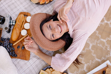 young beautiful woman in a hat on a picnic top view. Sunny day weekend. Summer evening atmosphere....
