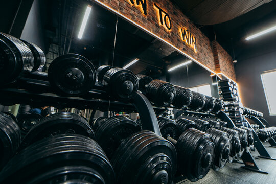 Kyiv, UKRAINE - May 12, 2022: Interior of gym with equipment and many black dumbbells