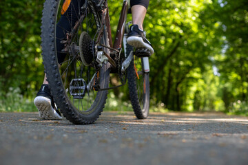 Naklejka premium young woman riding bicycle in the park