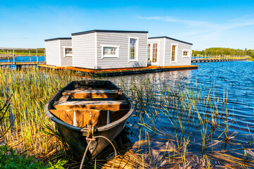 Floating fishing cabins on the blue water of a park lake