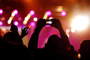 Hand with a smartphone records live music festival, Taking photo of concert stage, live concert, music festival.