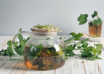 Herbal tea in a teapot with herbs and flowers. Benefits of herbal tea.