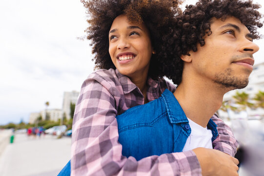 Young afro african american couple piggybacking while spending leisure time together