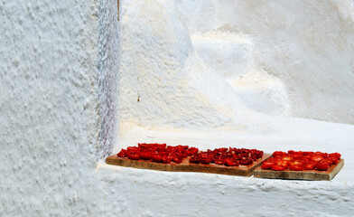 Trays of red tomatoes to dry in the sun for food use in the village of Oia, Greece