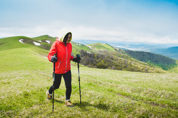 Female hiker nordic walk trekking outdoors in spring nature. Ikvlivi mount loop hike.