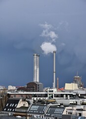Rauchende Schornsteine – Kraftwerk Mitte vor dunkelblauer Wetterwolke