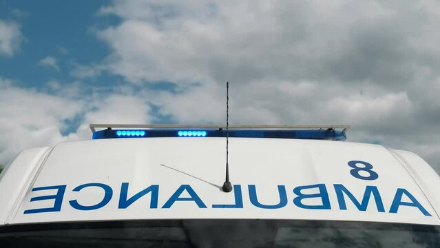 Blue signal lights flashing on the ambulance in close-up.