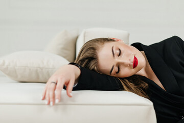 Obraz premium beautiful sexy young girl lying on the sofa with closed eyes enjoys the moment