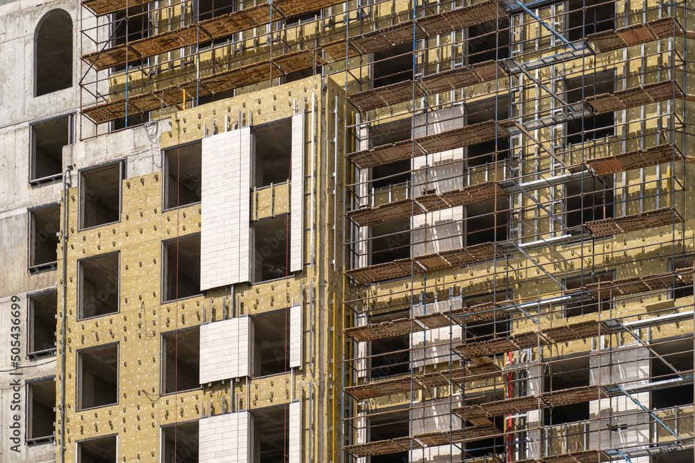 Poster installation of external wall thermal insulation with rock wool. monolithic concrete frame of apartm