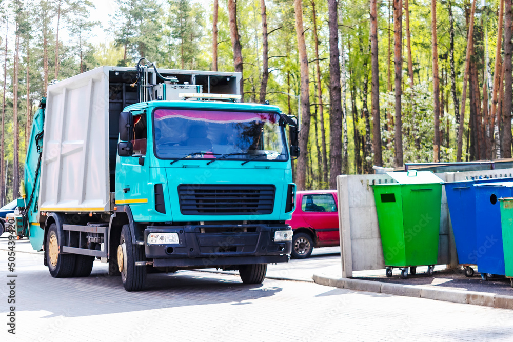 Leinwandbilder A garbage truck picks up garbage in a residential area. Loading mussar in containers into the car. Separate collection and disposal of garbage. Garbage collection vehicle.