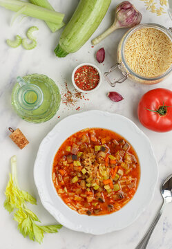 Homemade thick soup of fresh vegetables (zucchini, eggplant, carrot, onion, garlic, celery, bell pepper, tomatoes), pasta (orzo, risoni) with spices and olive oil. Minestrone. Mediterranean cuisine