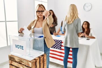 Group of young girls voting at democracy referendum looking unhappy and angry showing rejection and negative with thumbs down gesture. bad expression. - obrazy, fototapety, plakaty