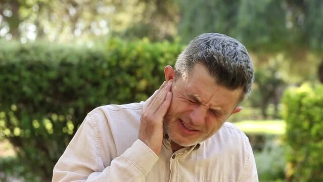 male having ear pain, touching his painful  aching  ear.  pain concept.