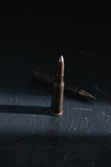 Two old cartridges on a dark background close-up. The concept of modern weapons and war