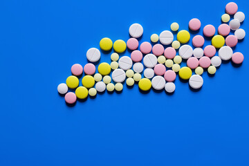 flat lay view of different round shape pills on blue background.
