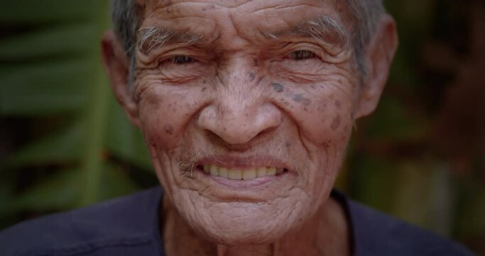 A happy smiling Asian male farmer who is the long life native 98 years, white hair, freckled skin, still in good health living in a rural farmer's village.