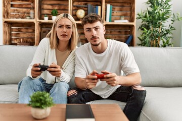 Young caucasian couple concentrated playing video game at home.