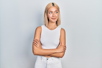 Fototapeta premium Beautiful blonde woman wearing casual style with sleeveless shirt smiling looking to the side and staring away thinking.