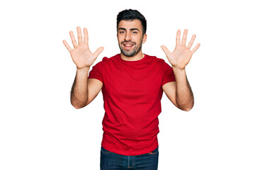 Hispanic man with beard wearing casual red t shirt showing and pointing up with fingers number ten while smiling confident and happy.