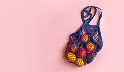 Net bag with fruit on bright background. Zero waste and ecology conservation concept. Fresh apples,...