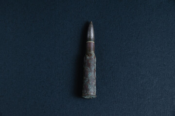 Cartridge closeup on dark gray concrete background, copy space. The concept of modern armaments, the war in Ukraine and the defense of the state.