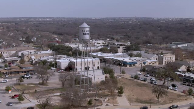 Aerial fly by of the water tower in downtown Round Rock, Texas on a sunny day.