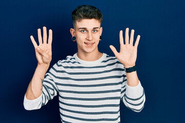 Young caucasian boy with ears dilation wearing casual striped shirt showing and pointing up with...