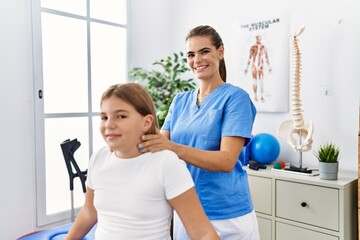 Woman and girl physiotherapist and patient having rehab session massaging neck at physiotherapy clinic