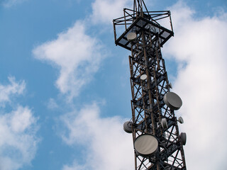 Radio tower with blue sky and some clouds. Radio tower for communication. Transmitting signals for radio, TV, mobile devices, 5G communication. 