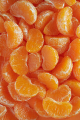 Wedges of juicy mandarin oranges filling the frame. Natural food orange fruit pattern.