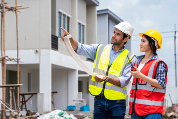 Two civil engineers man and woman inspecting  construction of house in village that they responsible for outdoors for construction of residential houses to be in accordance with standards and strong