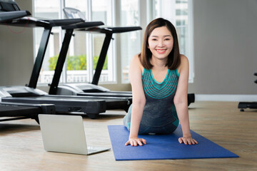 Fototapeta premium asian woman exercising doing yoga at fitness center smiling happily Have a strong body good health beautiful skin.