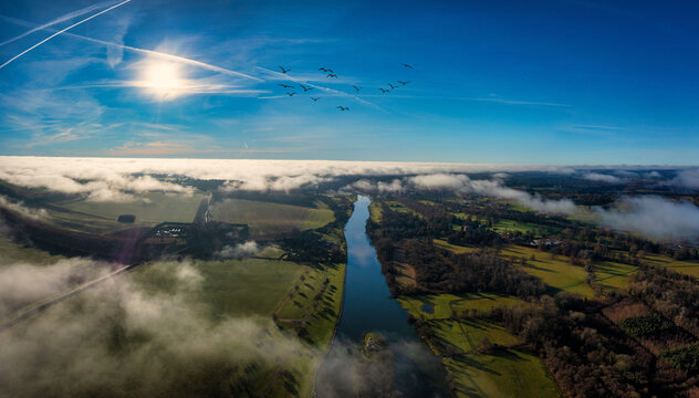 Aerial view of cityscape Henley-on-Thames surrounded by greenery fields and water