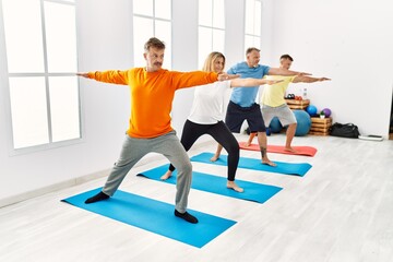 Fototapeta na wymiar Group of middle age people concentrate training yoga at sport center.