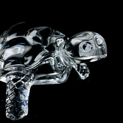 antique crystal figurine of a turtle. vintage figurine of a turtle on a black isolated background.