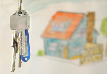 latchkey with key fob and blurred home in the back,buying house,real estate concept.Selective focus,free copy space