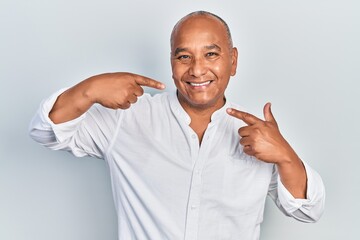 Middle age latin man wearing casual clothes smiling cheerful showing and pointing with fingers...