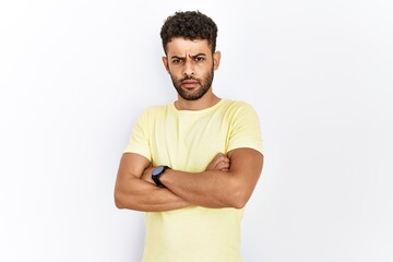 Arab young man standing over isolated background skeptic and nervous, disapproving expression on face with crossed arms. negative person.